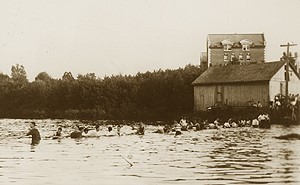 Duck Pond, now known as Swan Lake, was the scene of the freshmen-sophomore Rope Pull until the 1950s. This photo shows the 1915 event. The brick building in the background is Storrs Hall.