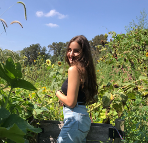 Rachel Maniace smiling in front of sunflowers